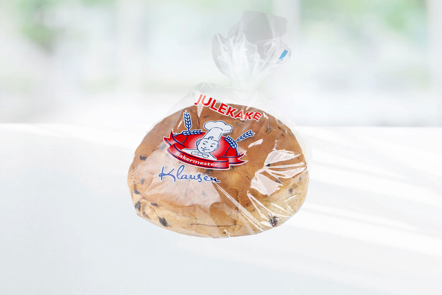 Rund julekake med rosiner og tre skårede julekakeskiver fra Baker Klausen